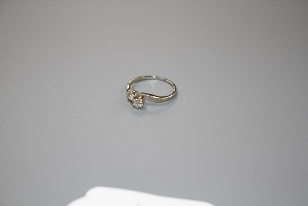 An 18ct and Plat, two stone diamond crossover ring, size P/Q, gross weight 2.5 grams.